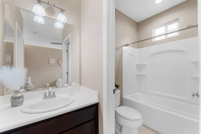 a bathroom with a sink a toilet a mirror and shower