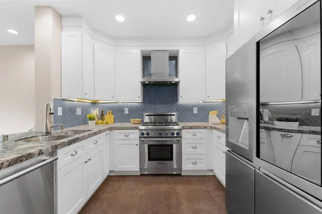a kitchen with stainless steel appliances granite countertop a stove and a refrigerator