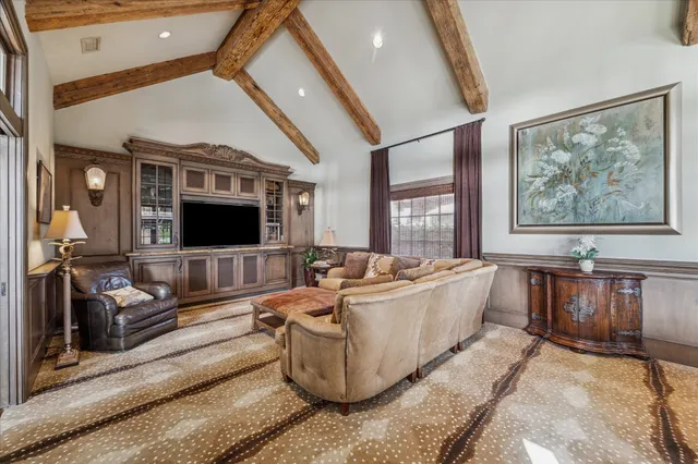 a spacious bedroom with a bed a table and windows