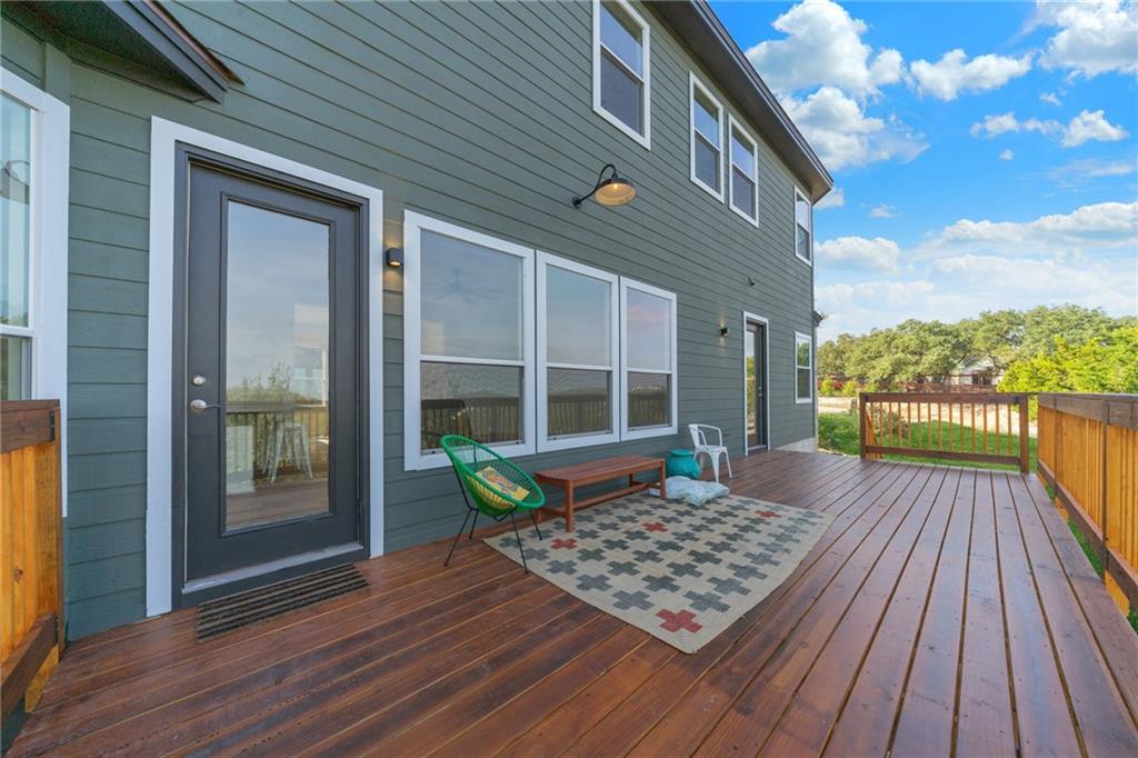 13301 Lone Rider Trail Bee Cave, TX 78738 - Photo 22 of 22 A spacious wooden deck extends from a contemporary home, offering an inviting outdoor living area.