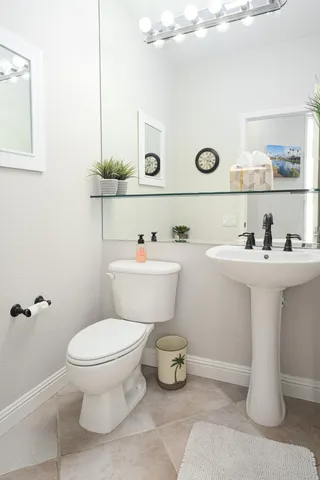 a bathroom with a sink a toilet and mirror