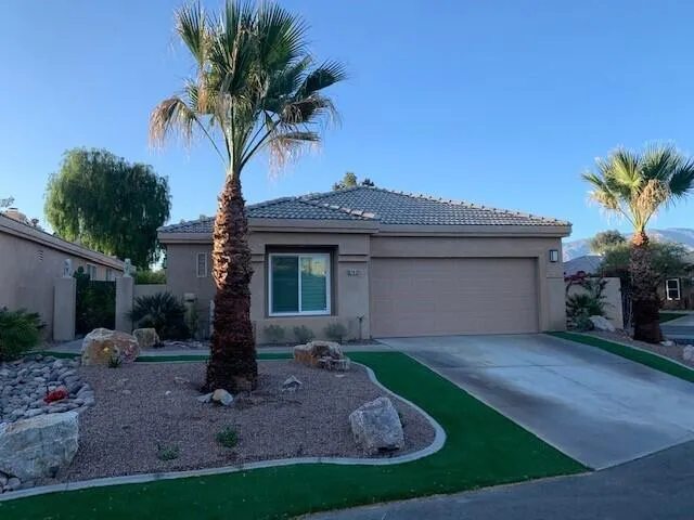 a front view of a house with a garden and yard