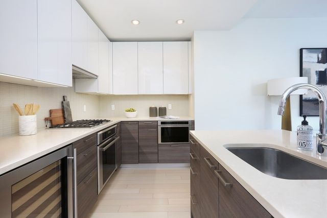 a kitchen with stainless steel appliances granite countertop a sink stove and cabinets