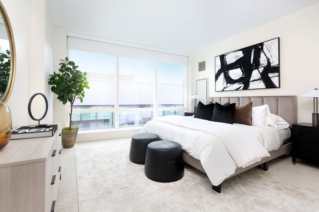 a bedroom with a bed dresser and window