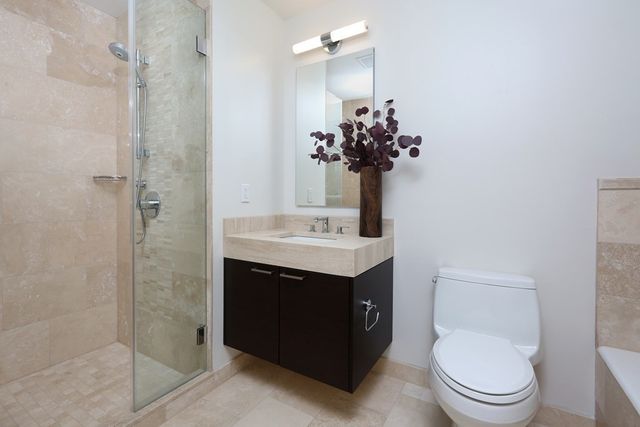 a bathroom with a sink a toilet and shower