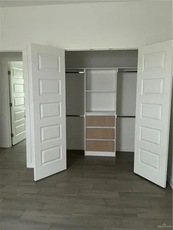 a view of walk in closet with empty racks
