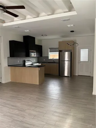 a view of kitchen with microwave stove refrigerator and oven