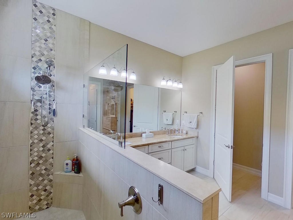 8920 Rails End Court Fort Myers, FL 33919 - Photo 11 of 35 a bathroom with a sink a large mirror and a shower