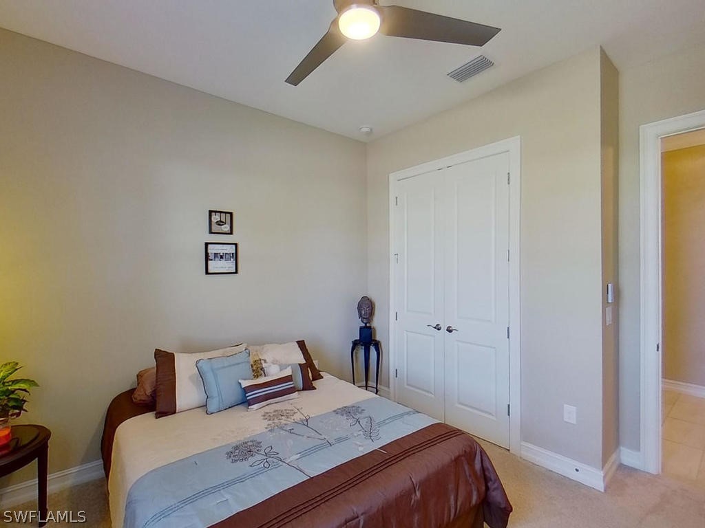 8920 Rails End Court Fort Myers, FL 33919 - Photo 14 of 35 a bedroom with a bed and a chandelier