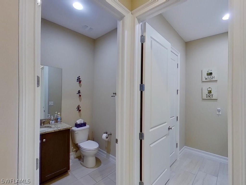 8920 Rails End Court Fort Myers, FL 33919 - Photo 15 of 35 a bathroom with a granite countertop toilet a sink and a mirror