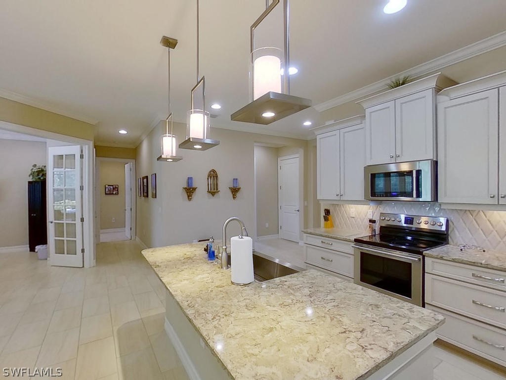 8920 Rails End Court Fort Myers, FL 33919 - Photo 6 of 35 a kitchen with stainless steel appliances granite countertop a sink a stove and a refrigerator