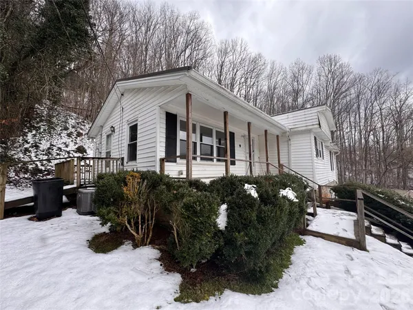 a front view of house with yard and trees in the background