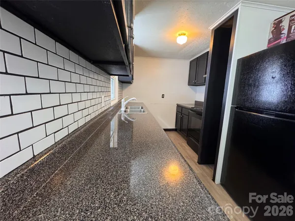 a kitchen with granite countertop a stove and a wooden cabinets