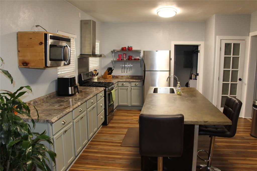 503 West 9th Street Cisco, TX 76437 - Photo 3 of 9 a kitchen with a table chairs microwave and refrigerator