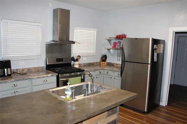 a kitchen with a refrigerator and a stove top oven
