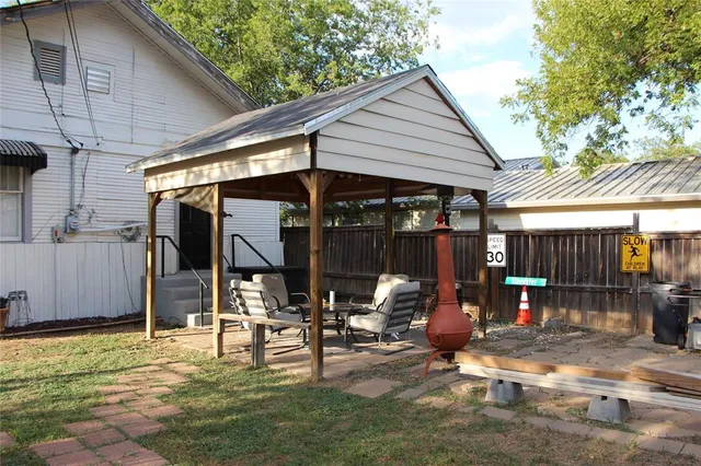 a view of a patio with table and chairs under an umbrella