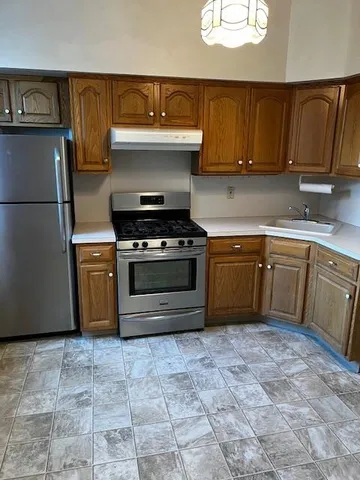 a kitchen with a stove top oven cabinets and a refrigerator