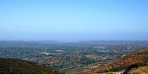an aerial view of house with yard and mountain view in back