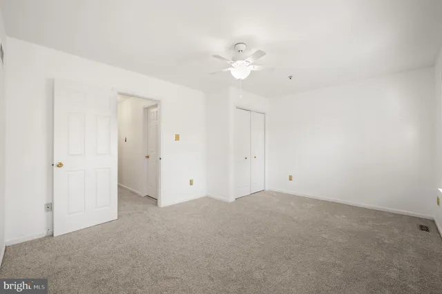 a view of an empty room with a chandelier fan