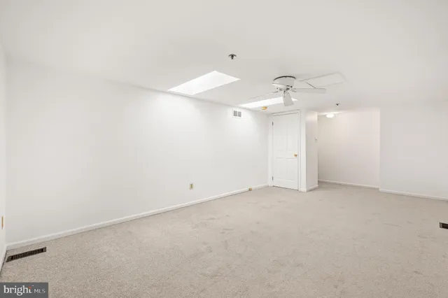 an empty room with an entryway and fan