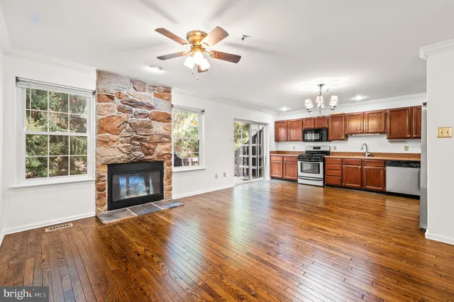 a view of a kitchen with a stove wooden floor and a fireplace