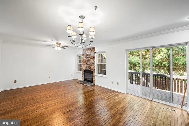 a view of a big room with wooden floor and windows