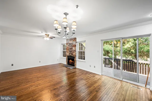 a view of a big room with wooden floor and windows