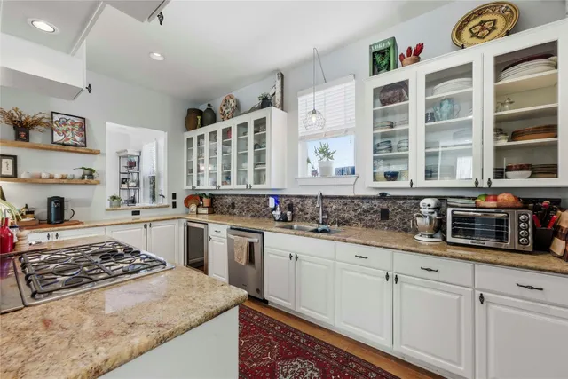 a kitchen with stainless steel appliances granite countertop a stove and a sink