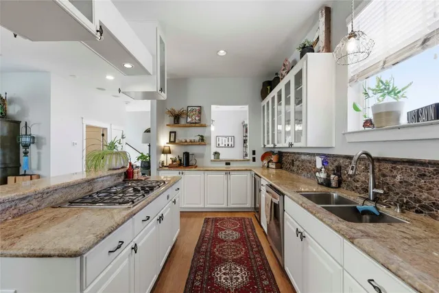 a kitchen with stainless steel appliances a sink stove and cabinets