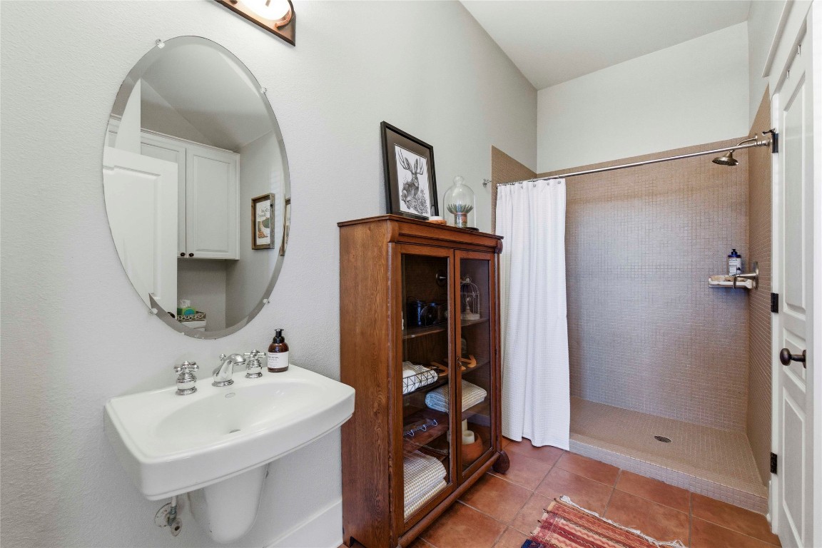 2128 Sage Creek Loop Austin, TX 78704 - Photo 22 of 32 a bathroom with a sink a mirror and shower