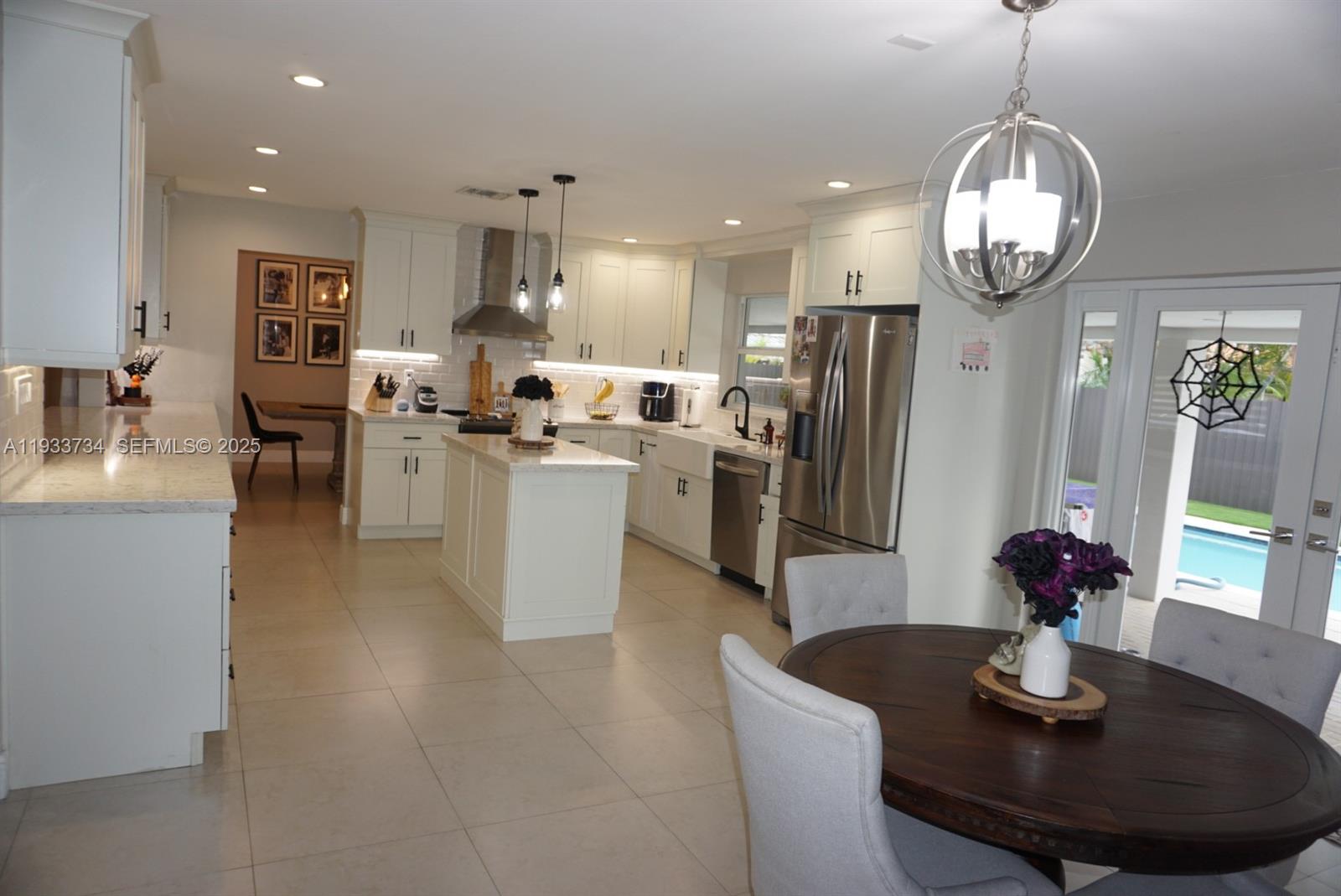 10350 Southwest 16th Street Miami, FL 33165 - Photo 16 of 48 a kitchen with stainless steel appliances granite countertop a sink dining table and chairs