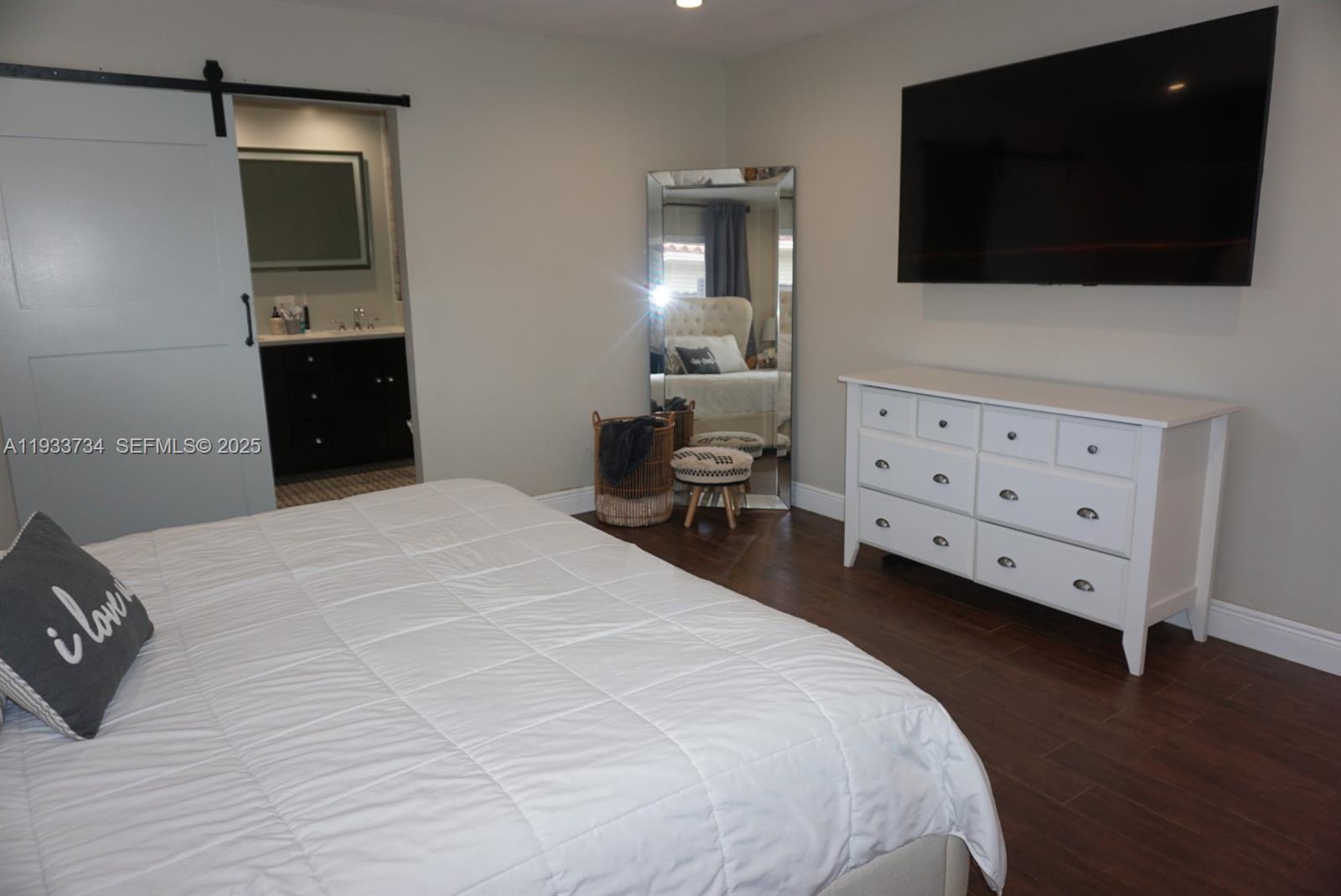 10350 Southwest 16th Street Miami, FL 33165 - Photo 28 of 48 a bedroom with a bed and a flat tv screen on dresser