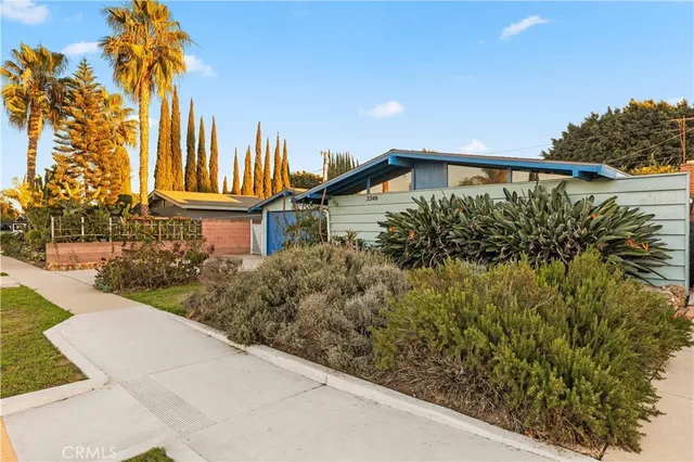 a view of a house with a yard and potted plants