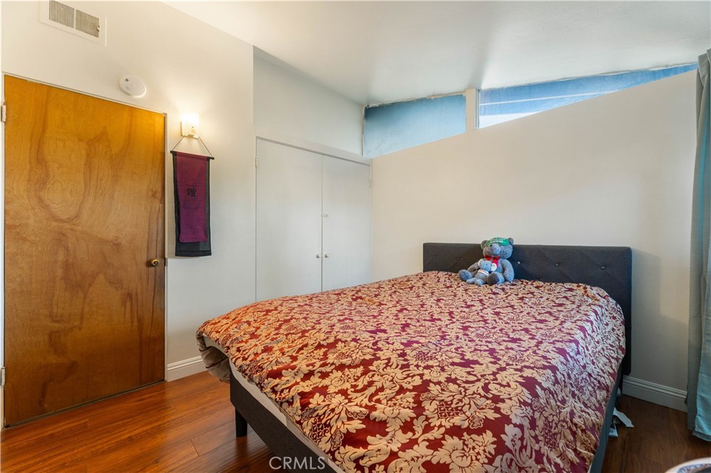 3340 East Poppy Street Long Beach, CA 90805 - Photo 21 of 39 a bedroom with a bed and wooden floor