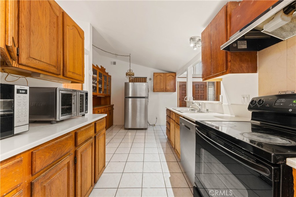 3340 East Poppy Street Long Beach, CA 90805 - Photo 29 of 39 a kitchen with stainless steel appliances granite countertop a stove and a refrigerator