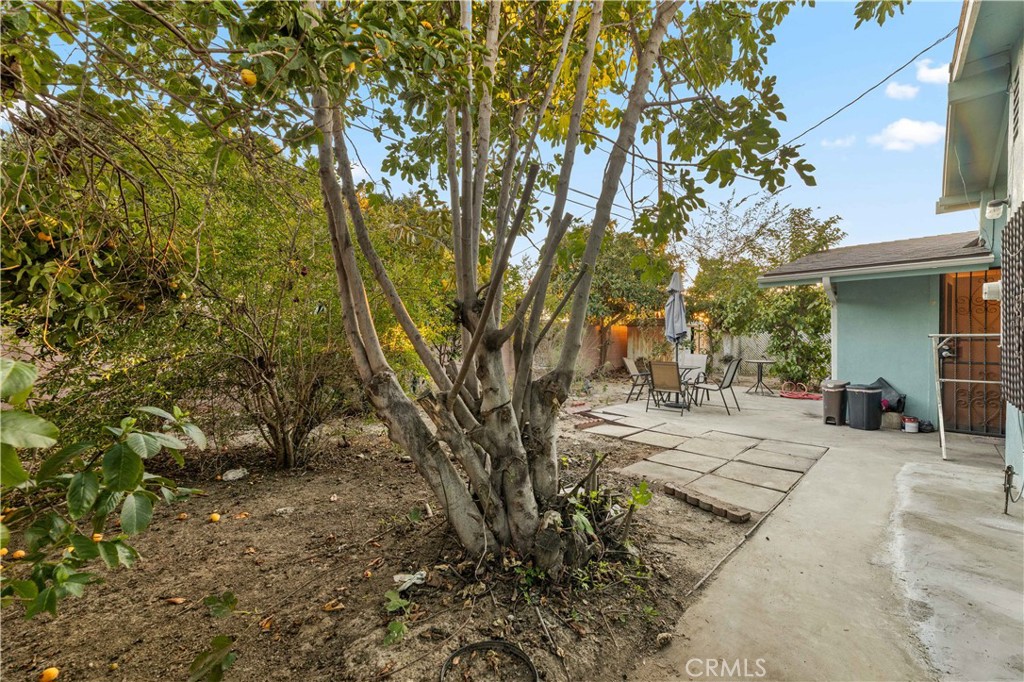 3340 East Poppy Street Long Beach, CA 90805 - Photo 38 of 39 a view of a backyard with table and chairs and a large tree
