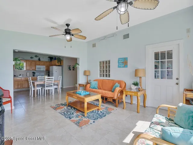 a living room with furniture a chandelier and a dining table