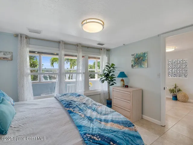 a room with a bed and a potted plant