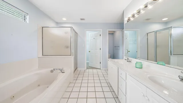 a bathroom with a tub sink and mirror