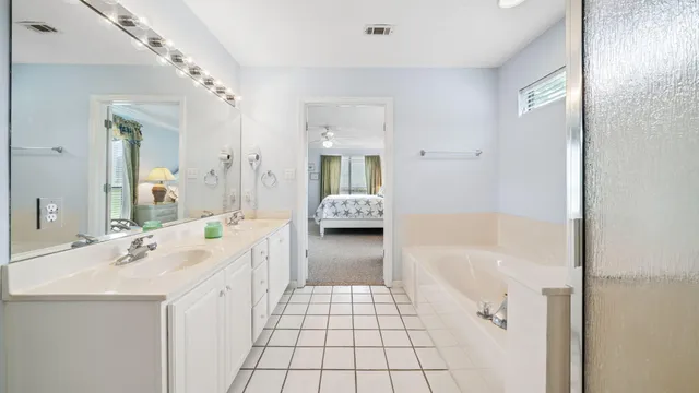 a bathroom with a tub sink and mirror