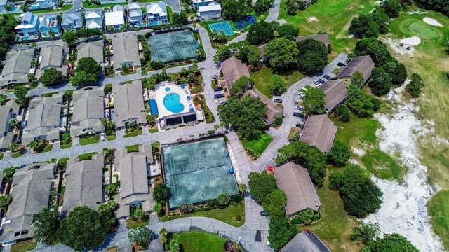 an aerial view of a house with a swimming pool and large trees