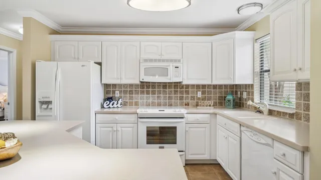 a kitchen with white cabinets and white appliances