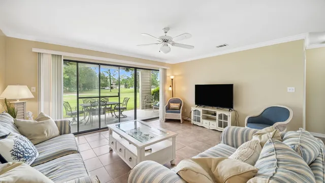 a living room with furniture a flat screen tv and a large window