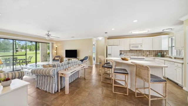 a large white kitchen with a large window and stainless steel appliances