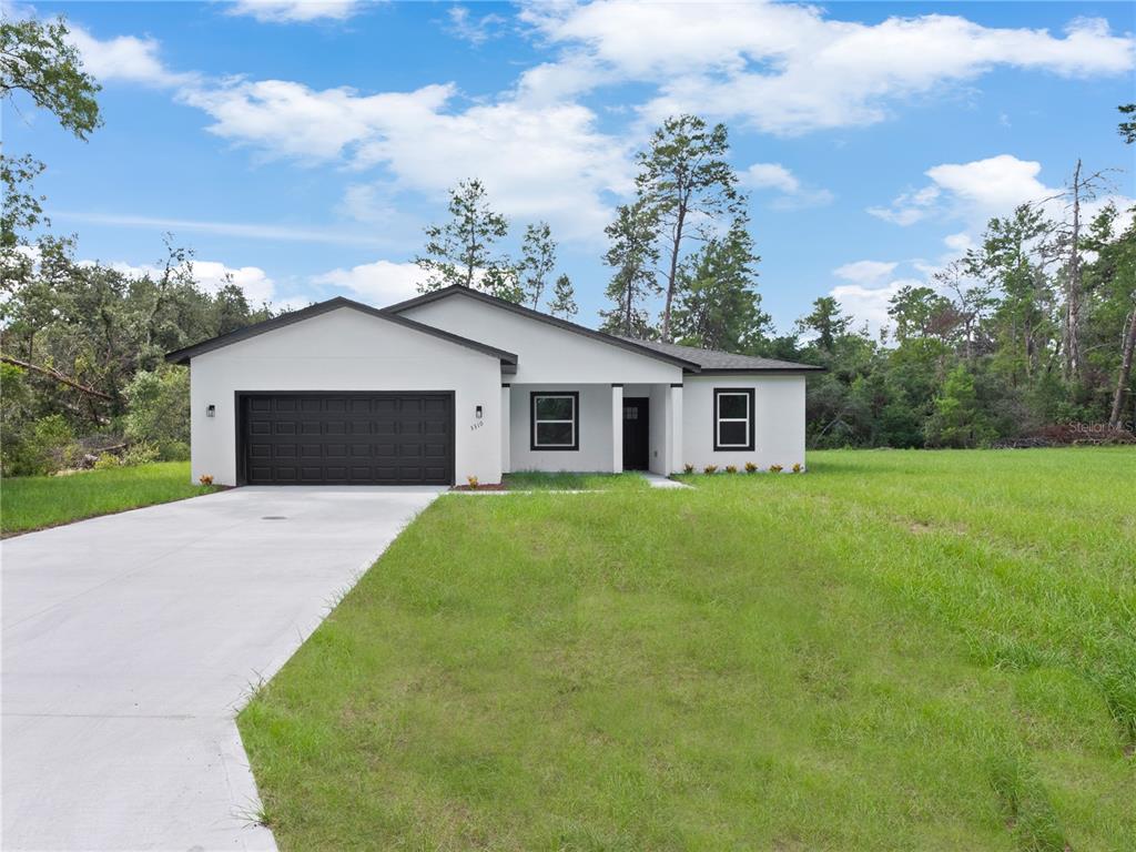 3310 Southwest 177th Lane Road Ocala, FL 34473 - Photo 1 of 40 a front view of house with a garden