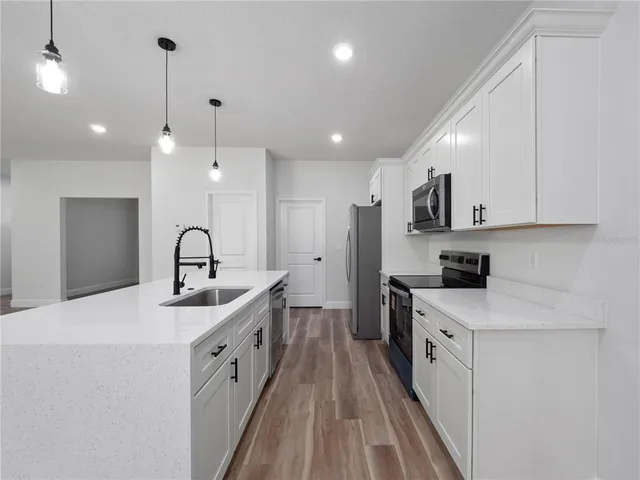 a kitchen with white cabinets appliances and sink