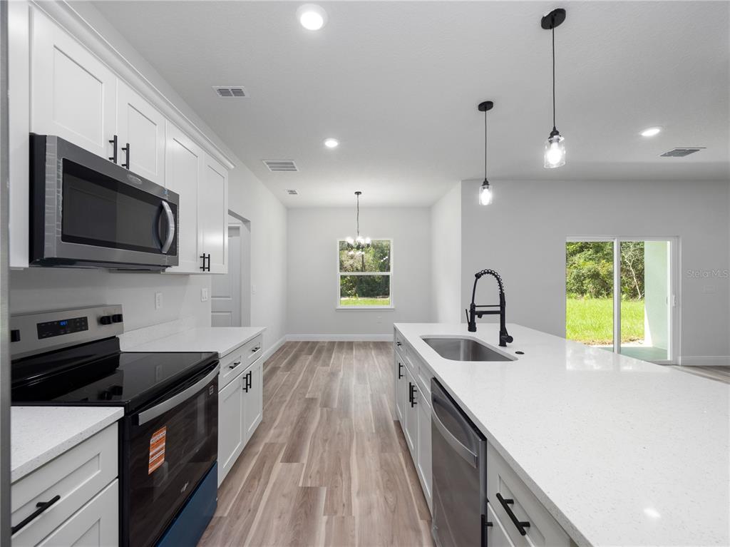 3310 Southwest 177th Lane Road Ocala, FL 34473 - Photo 27 of 40 a kitchen with a sink stove and microwave