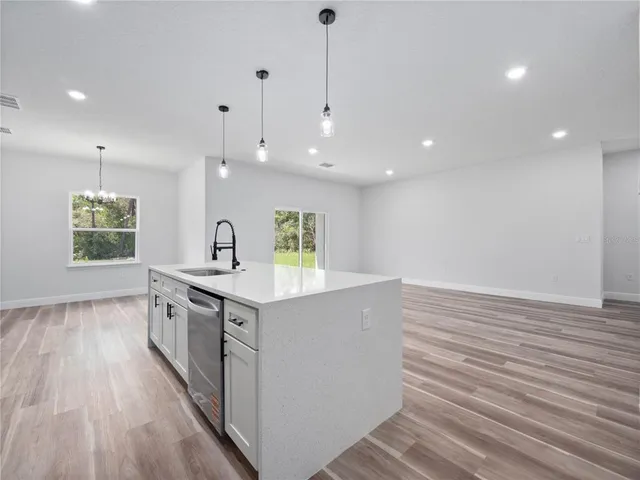 a kitchen with stainless steel appliances granite countertop a sink stove and wooden floor