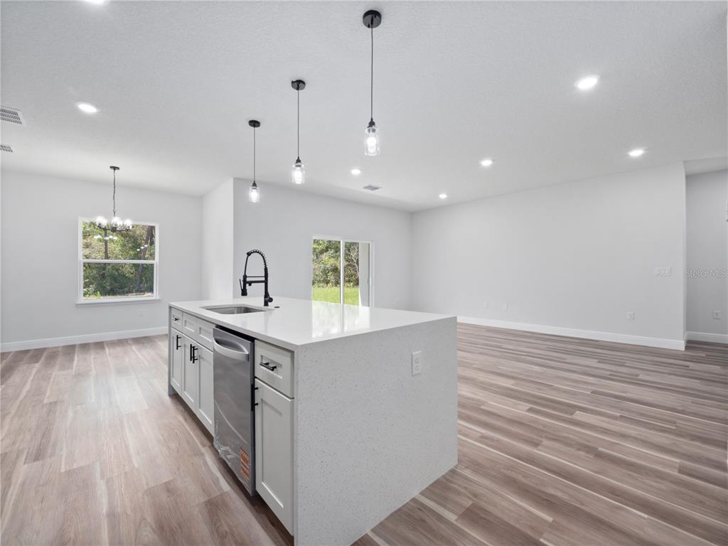 3310 Southwest 177th Lane Road Ocala, FL 34473 - Photo 28 of 40 a kitchen with stainless steel appliances granite countertop a sink stove and wooden floor