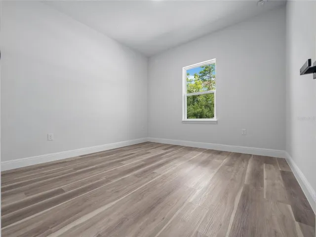 a view of a room that has wooden floor and window in it